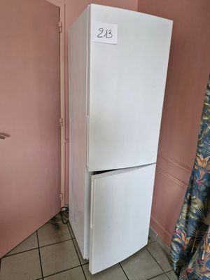 un réfrigérateur blanc dans un coin d'une pièce aux murs roses