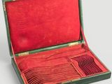 un étui vert doublé de rouge, contenant une cuillère en argent
