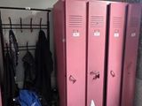 two pink lockers and a chair in a room