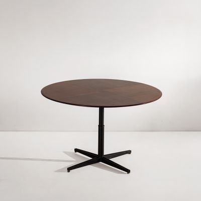 une table ronde avec un piètement en métal noir et un plateau en bois
