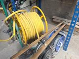 un tuyau jaune posé sur un chariot dans un garage