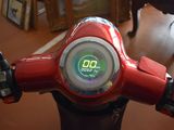 a red motorcycle with a digital clock on the handlebars