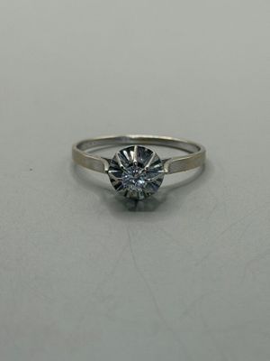 a close up of a diamond ring on a white surface