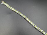 un gros plan d'un bracelet vert et blanc posé sur une surface noire
