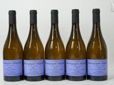 six bouteilles de vin sont alignées sur une table