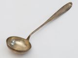 a spoon that is sitting on a white surface