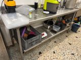 stainless steel work table with bins and containers on it