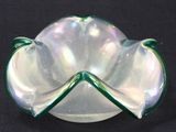a green and white glass bowl on a black surface