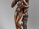 bronze statue of a woman holding a bunch of grapes in her hands