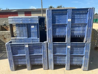 four blue plastic crates stacked on top of each other in a yard