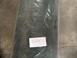une photo d'un rouleau de tissu vert posé par terre