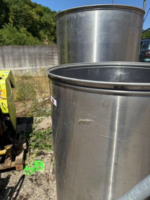 un grand seau en métal posé à côté d'un autre grand seau en métal