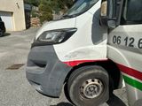 a white truck with a red and green stripe parked in a parking lot