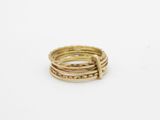 an image of a stack of gold rings on a white surface