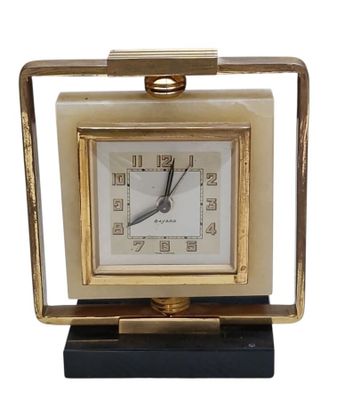 l'image d'une petite horloge avec un cadre doré sur fond blanc