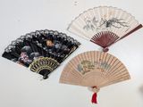 three chinese fans are displayed on a white surface