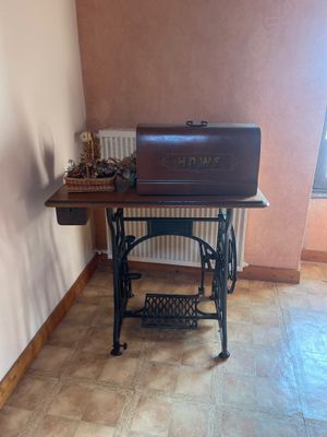 une petite table sur laquelle est posé un ordinateur portable, dans un coin de la pièce