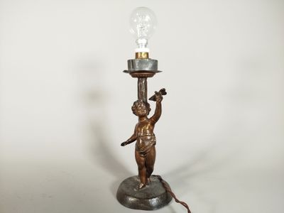 an image of a lamp with a statue holding a light bulb