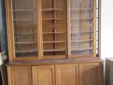 un vaisselier en bois avec des portes en verre dans une pièce