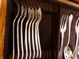 Plusieurs fourchettes et cuillères sont rangées dans un coffret en bois