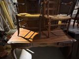 un bureau avec une chaise et une chaise posée dessus, dans une pièce