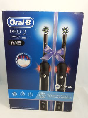 two black electric toothbrushes in a box on a white surface