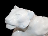 a white statue of a lion on a black background