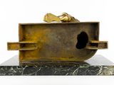 bronze sculpture of a man ' s foot sticking out of a box