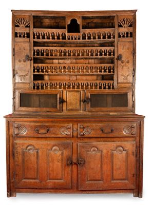 une vieille armoire en bois sur laquelle sont posées de nombreuses bouteilles