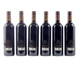 six bottles of wine are lined up on a white surface
