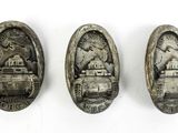 three silver medals with a picture of a tank on them