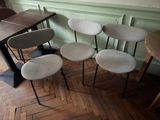 plusieurs chaises et une table dans une pièce au sol en parquet