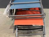 four folding chairs are stacked on top of each other in front of a black wall