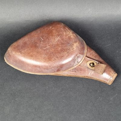 selle de moto en cuir marron posée sur une surface noire, avec un fond noir