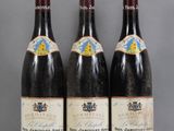 three bottles of wine are lined up on a table
