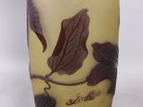a glass vase with a design of leaves on it