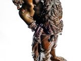 figurine en bronze représentant un garçon tenant un oiseau, posée sur un socle