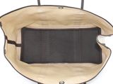 the inside of a black and tan purse with a black handle