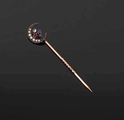 a gold, diamond and sapphire stick with a crescent on it