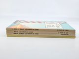 three books are stacked on top of each other on a white surface