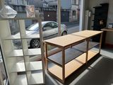 une table au milieu d'une pièce, avec une voiture en arrière-plan