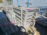 a large pile of steel pipes in front of a building