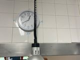 une horloge accrochée au mur au-dessus d'un évier dans une cuisine