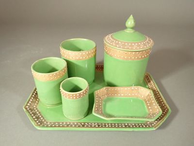 un plateau vert sur lequel sont posés des tasses et des soucoupes