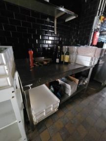 une cuisine avec un plan de travail noir et un mur carrelé noir