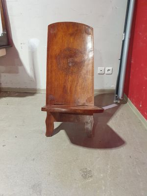 une chaise en bois posée dans une pièce aux murs rouges