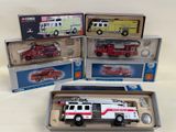 three boxed toy fire trucks in boxes on a white surface