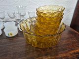 a stack of yellow glass bowls sitting on a wooden table