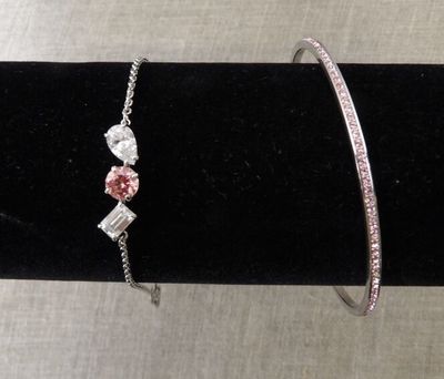 un gros plan sur deux bracelets posés sur un fond de velours noir