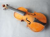 an old violin sitting on top of a table next to a wall